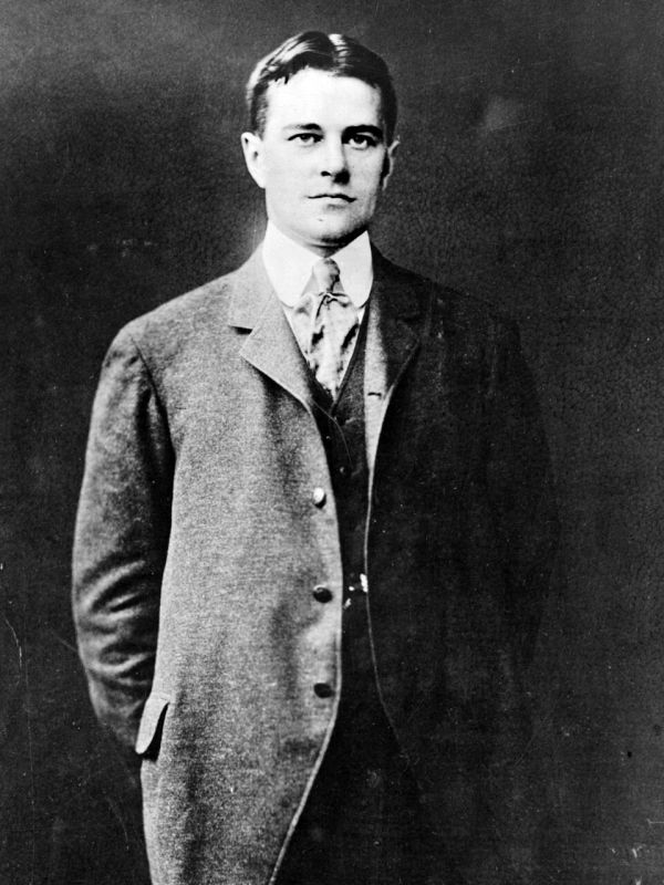 Black and white portrait of a young man in a suit.