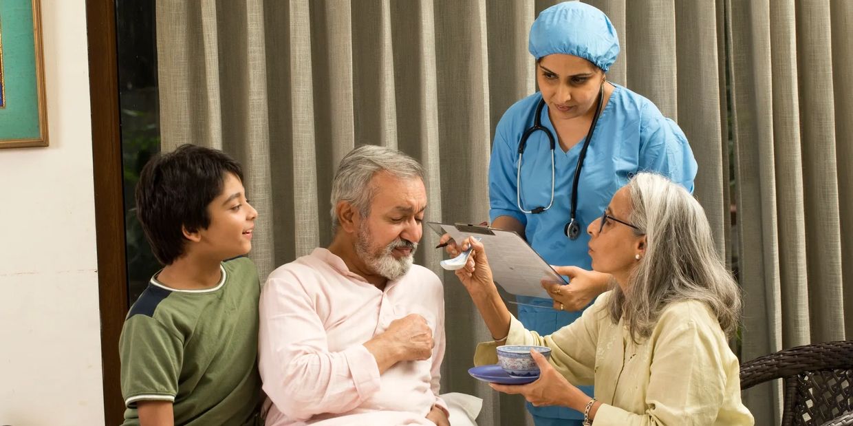 Elderly man being cared for by family and nurse.