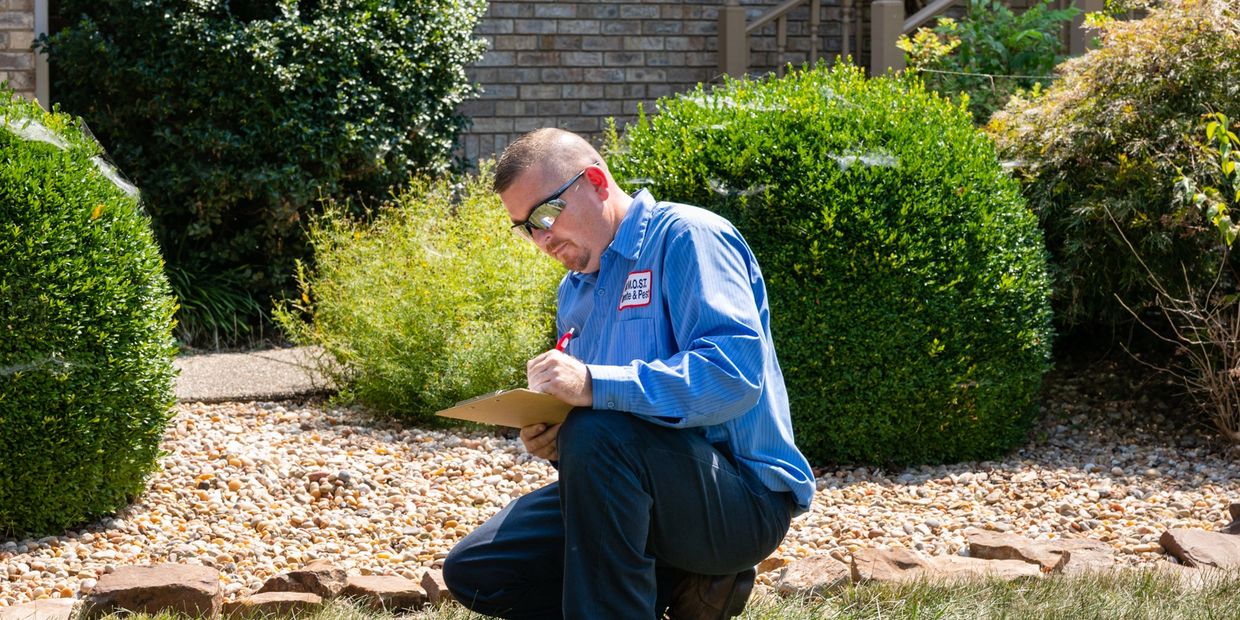 MOST Termite & Pest Control technician working outside a home.