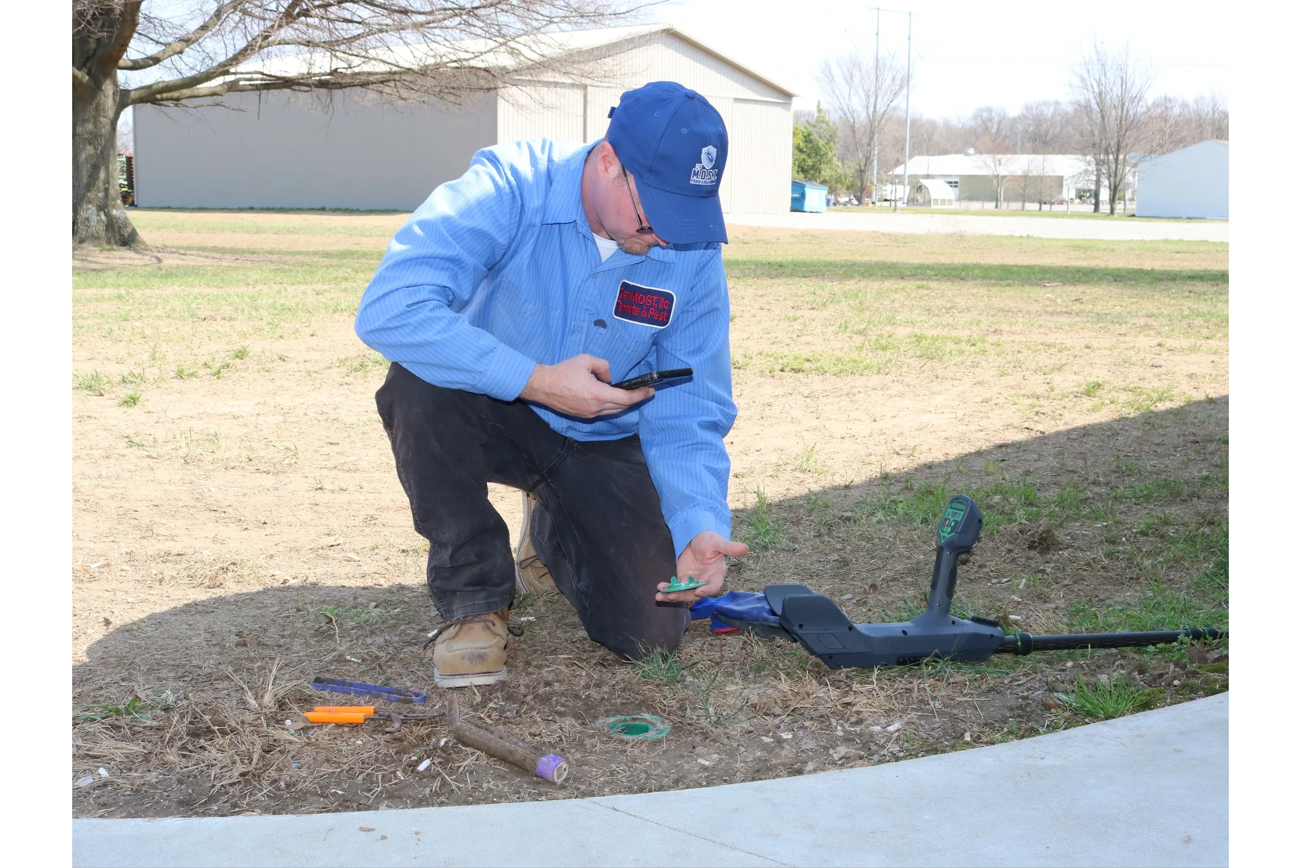 Trained technician checking Sentricon bait system at a client's property.