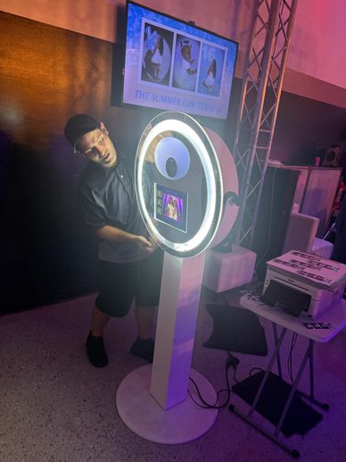 Man leaning on a lit photo booth station.