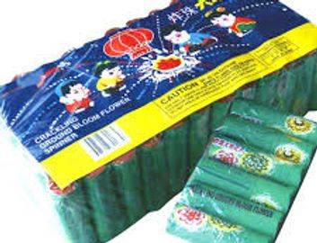 Green cylindrical firecrackers with colorful packaging.