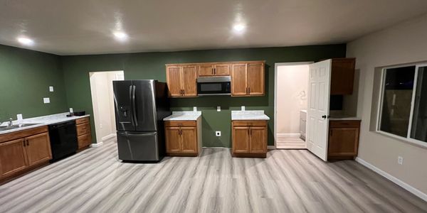 Modern kitchen with wooden cabinets and dark appliances.