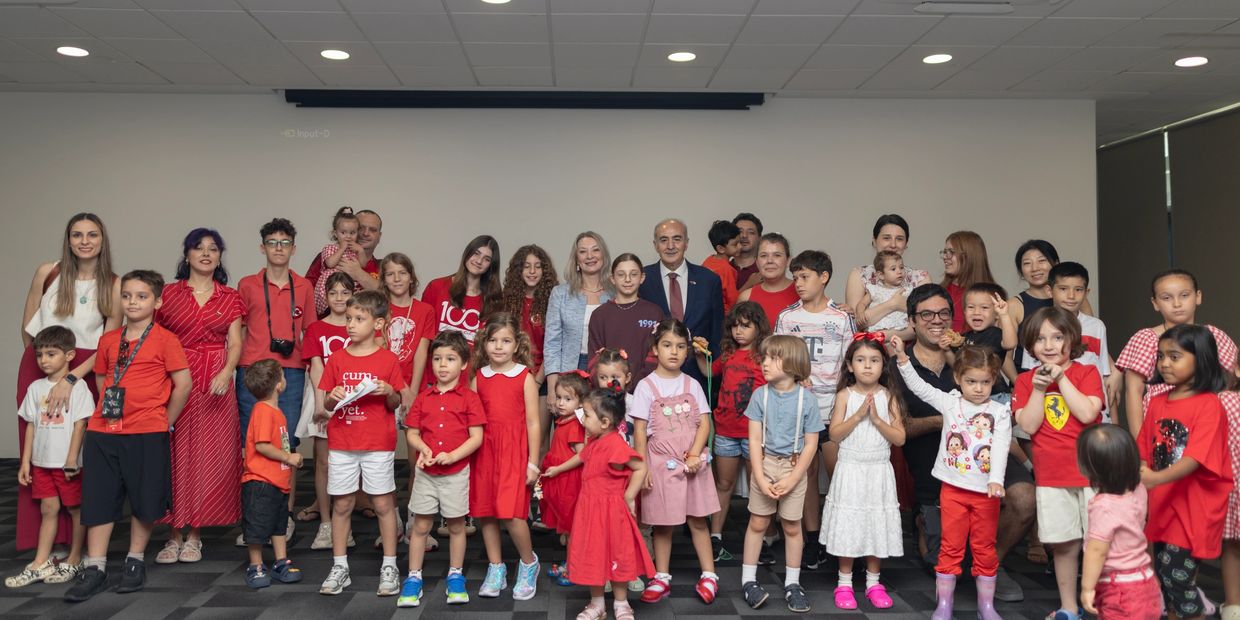 A large group of children and adults posing together indoors.