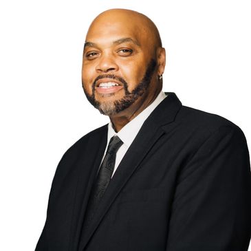 Smiling man in a black suit and tie against a white background.
