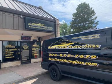 Bear Creek Autoglass shop with branded van parked outside under a blue sky.