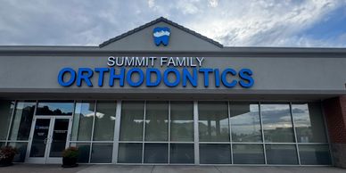 The exterior of Summit Family Orthodontics with a clear sign and cloudy sky.
