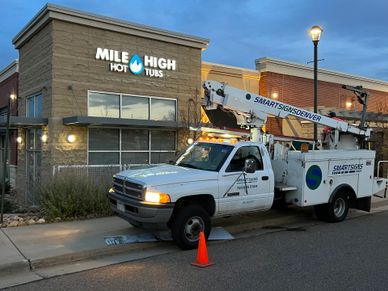 A service truck parked outside Mile High Hot Tubs during dusk.