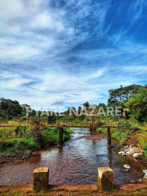 Scenic view of a small bridge over a river with a blue sky.