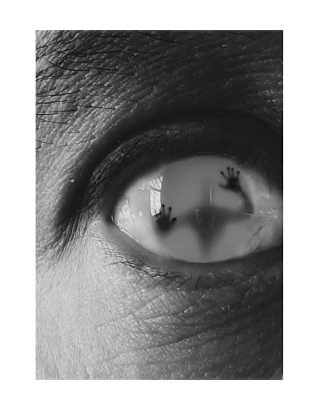Close-up of an eye with a shadowy figure pressed against the pupil.