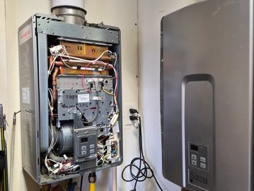Open tankless water heater showing internal components and wiring.