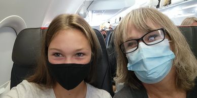 Mother and daughter on plane with masks.
