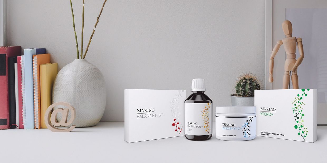 Zinzino health supplements and test kit displayed on a white desk with books and decor.