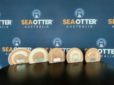 Five rock samples on a table with a Sea Otter Australia backdrop.