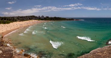 Panorama landscape beach photography of Freshwater Beach, Sydney, Australia with waves and cliffs.  