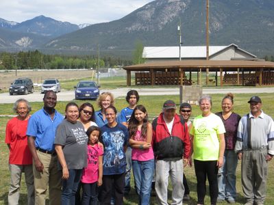 Group of people posing outdoors with mountains in the background.