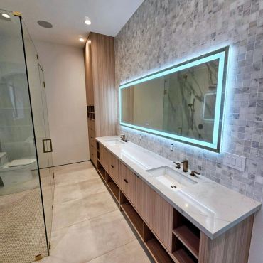 Modern bathroom with a double sink and illuminated mirror.