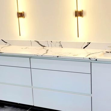 Modern white kitchen cabinets with marble countertop.