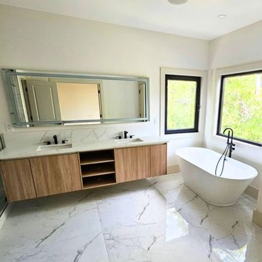 Modern bathroom with double vanity and freestanding tub.