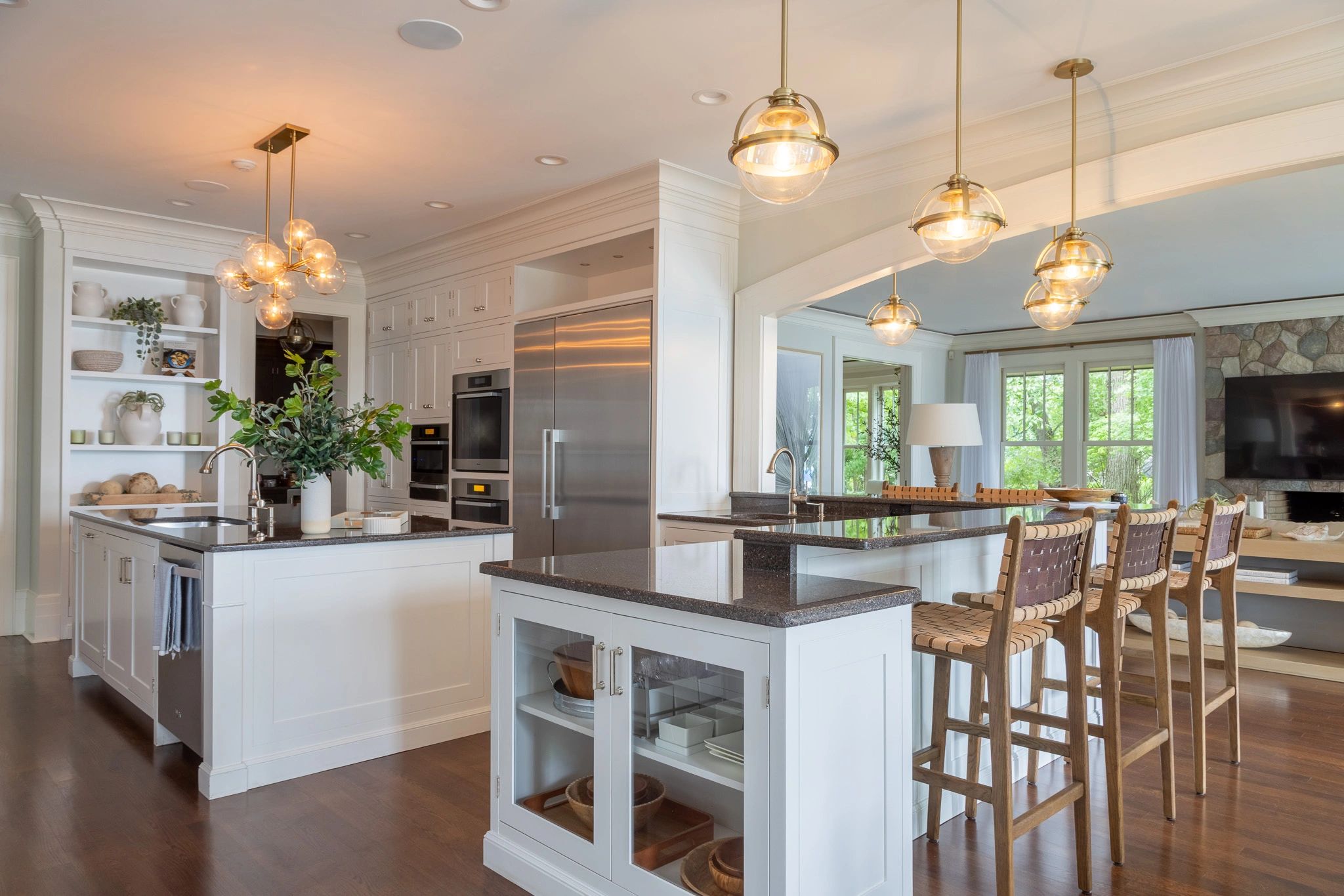 Elegant kitchen with white cabinetry, dark countertops, and stylish pendant lighting.