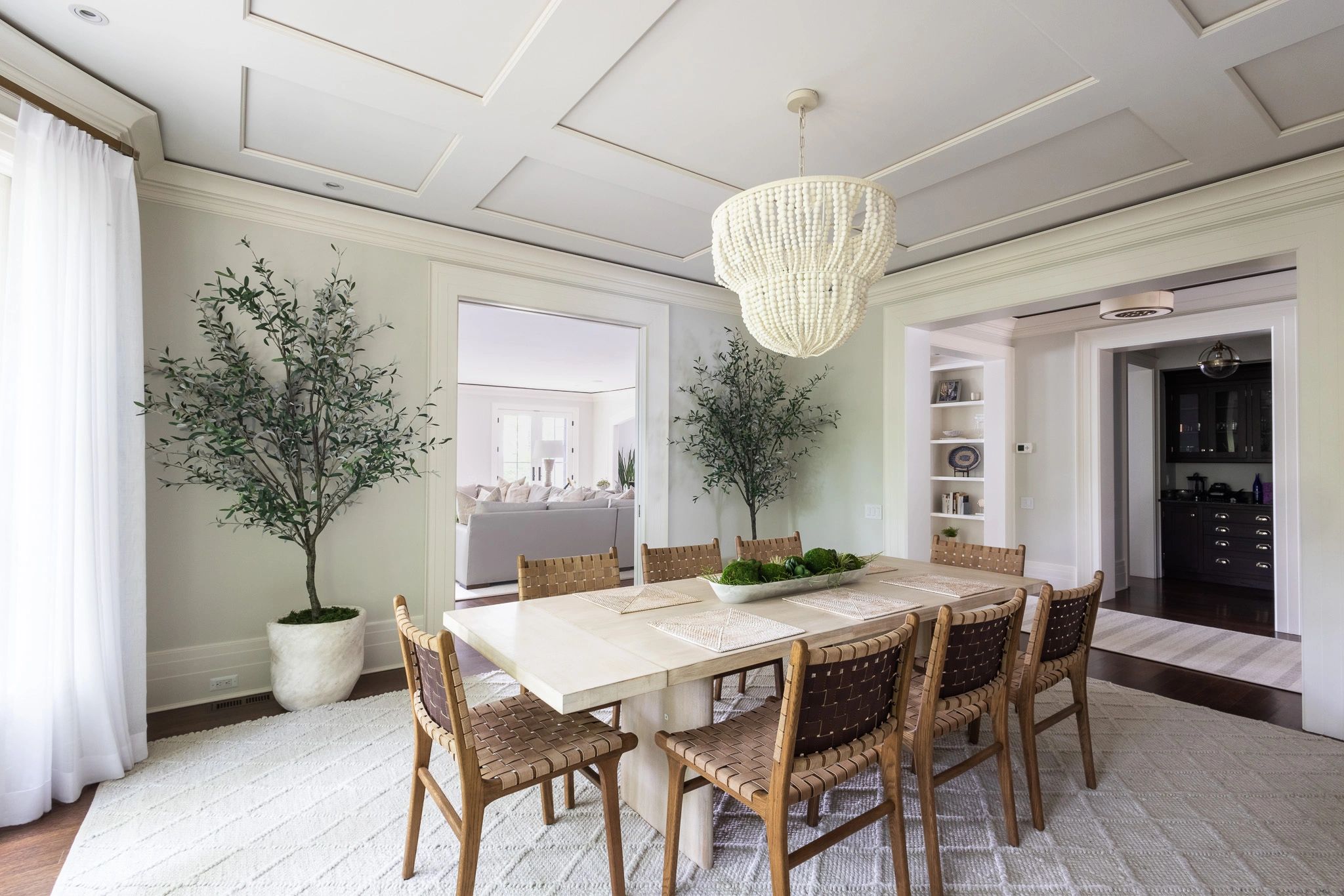 Elegant dining room with wooden chairs and a beaded chandelier.