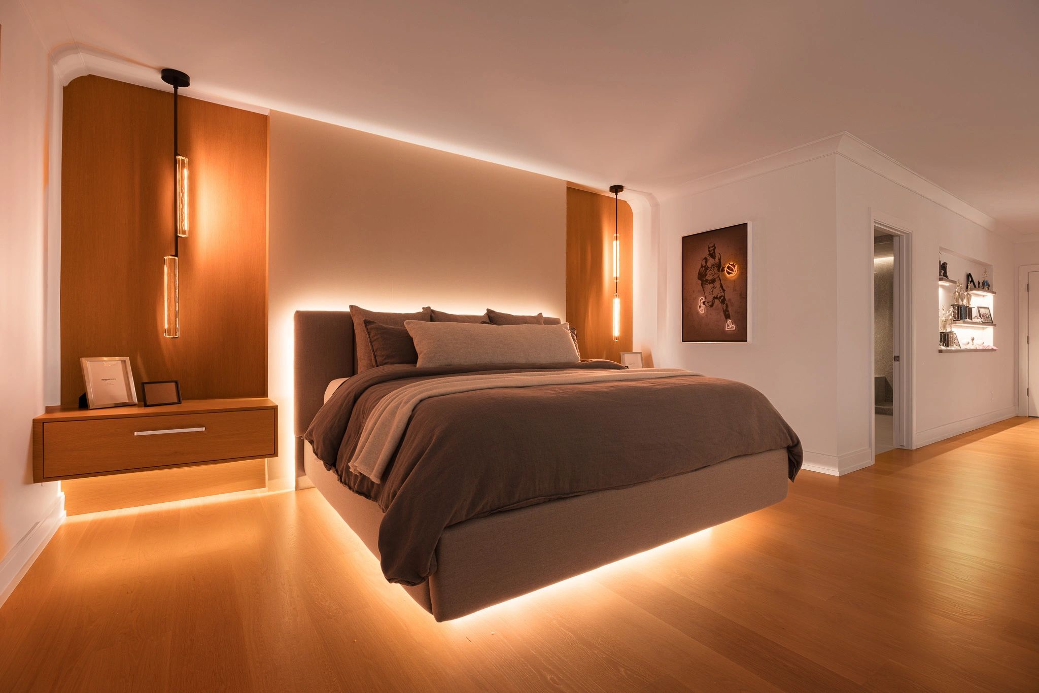 Modern bedroom with warm lighting and floating bed.