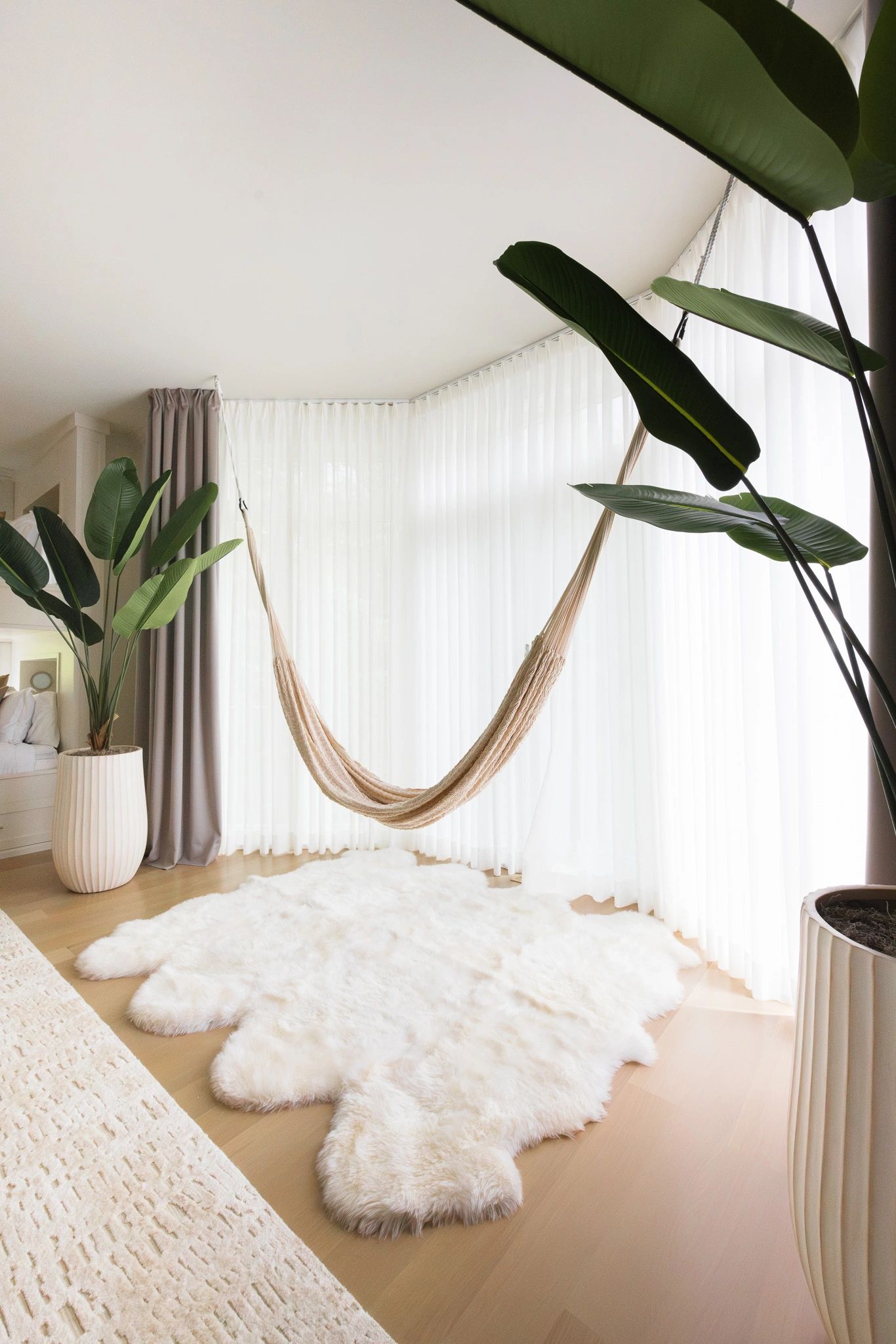 Bright room with a hammock and plants.