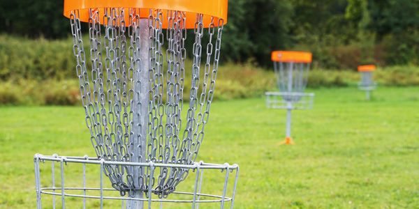 A grassy field of disc golf baskets