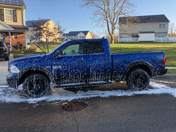 Blue Dodge Ram 1500 Foam Car Wash Bath on street with houses in background 