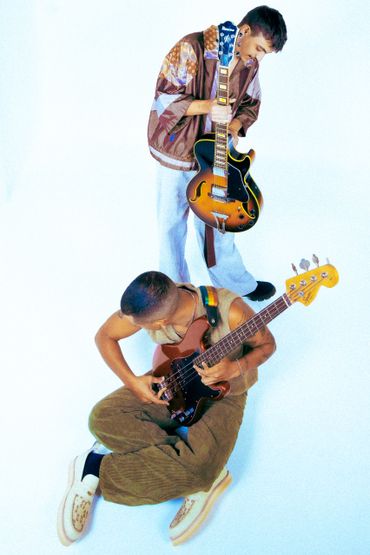 Two musicians with guitars on a white background.
