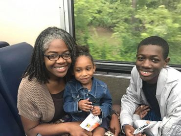 Mother and children riding in a scenic railroad car.