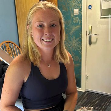 Blond lady sitting down smiling
