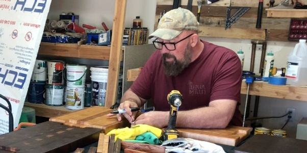 Bumpa working on a custom cutting board attaching the feet.
