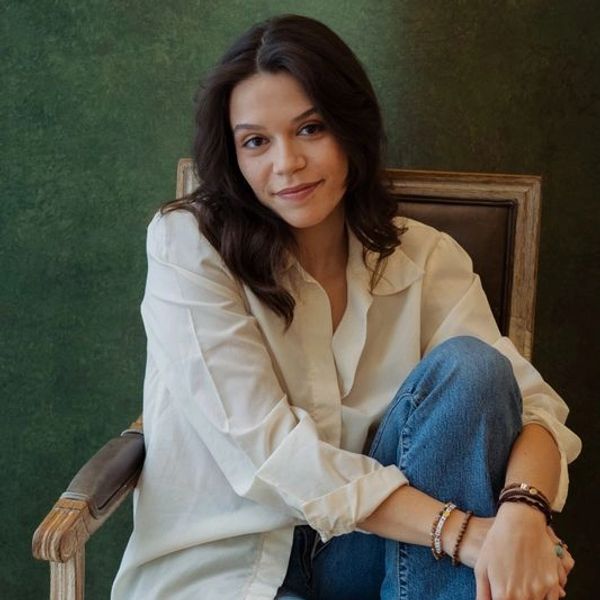 Young woman sitting on a chair with a relaxed smile.