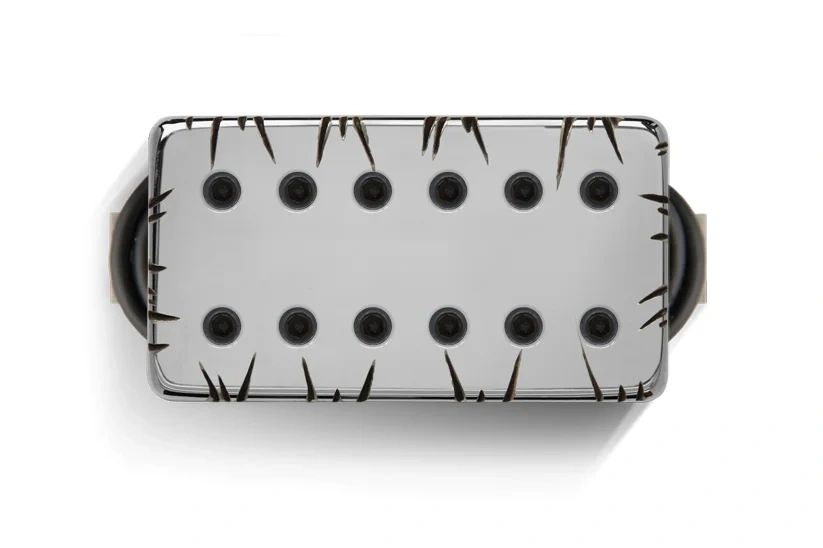 Close-up of a guitar pickup with a scratched metal cover.