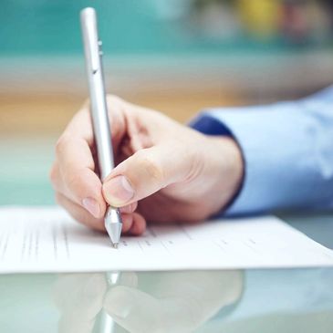 Hand of a person writing on a piece of professional paper/qualifications