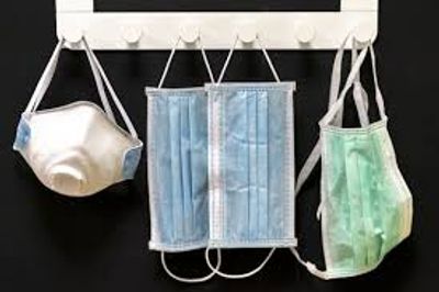 Various face masks hanging on hooks.