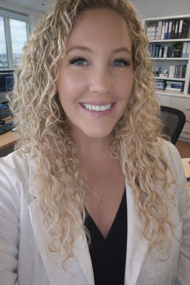 Smiling woman with curly blonde hair in an office.