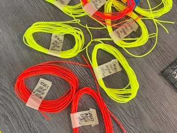 Colored fishing lines coiled on a surface.