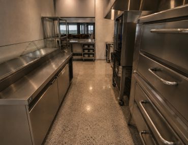 Clean industrial kitchen with stainless steel appliances.