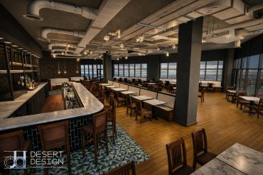 Spacious modern restaurant interior with wooden tables and chairs.