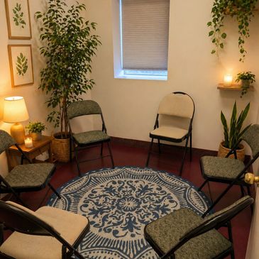 Cozy circle of chairs around a patterned rug in a softly lit room.