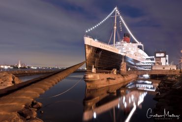 A large ship docked with lights at night.