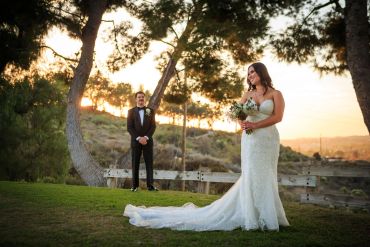 Bride and groom posing outdoors at sunset.