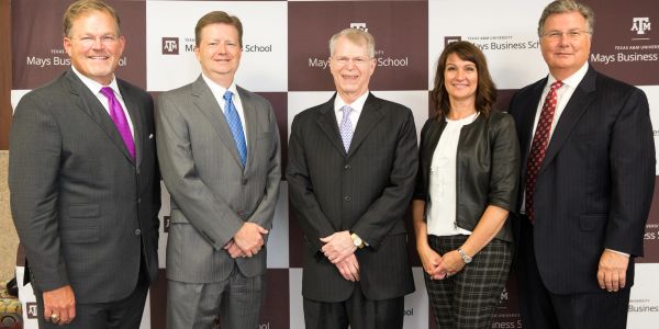Group of professionals posing at Texas A&amp;M Mays Business School event.