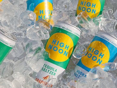 Cans of High Noon seltzer in ice, featuring tequila and vodka flavors.