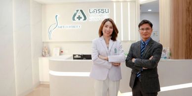 Two medical professionals standing confidently in a modern clinic reception area.