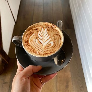 Coffee with latte art being held
