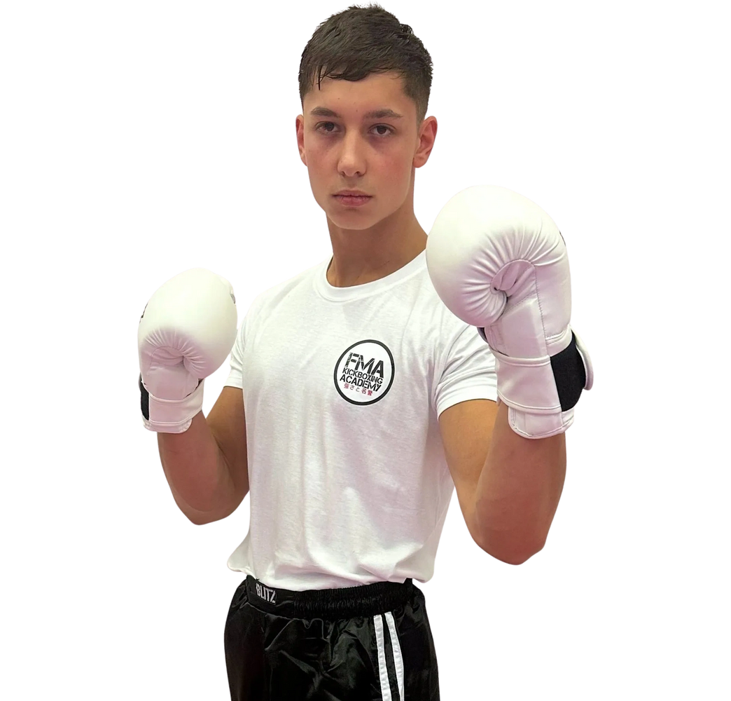 Young male kickboxer posing with white gloves and focused expression.