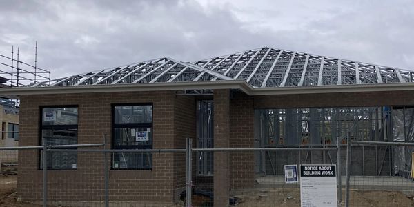A house under construction with steel frames and trusses.